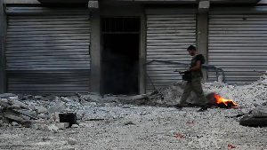 Free Syrian Army soldier walking among rubble in Aleppo